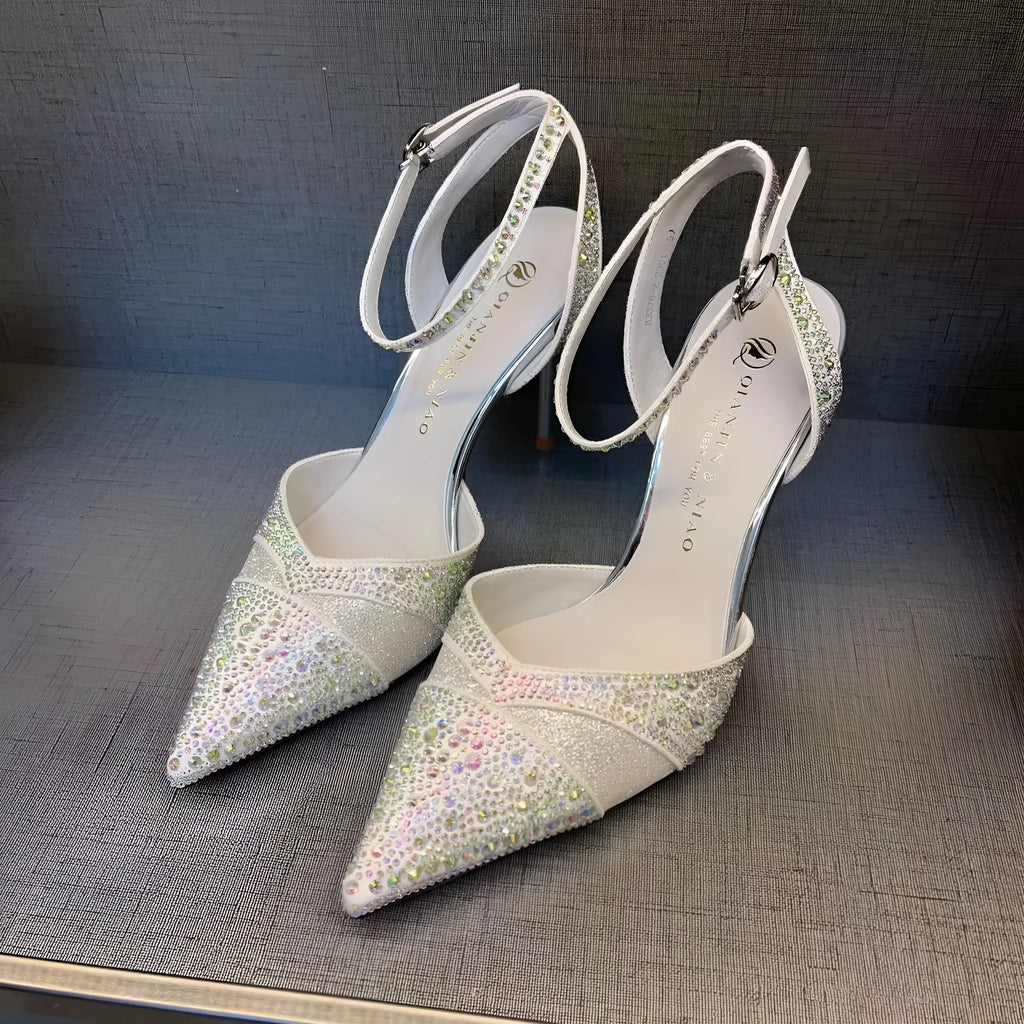 Women's black pointed toe stiletto heels with a hollow design and red sole.