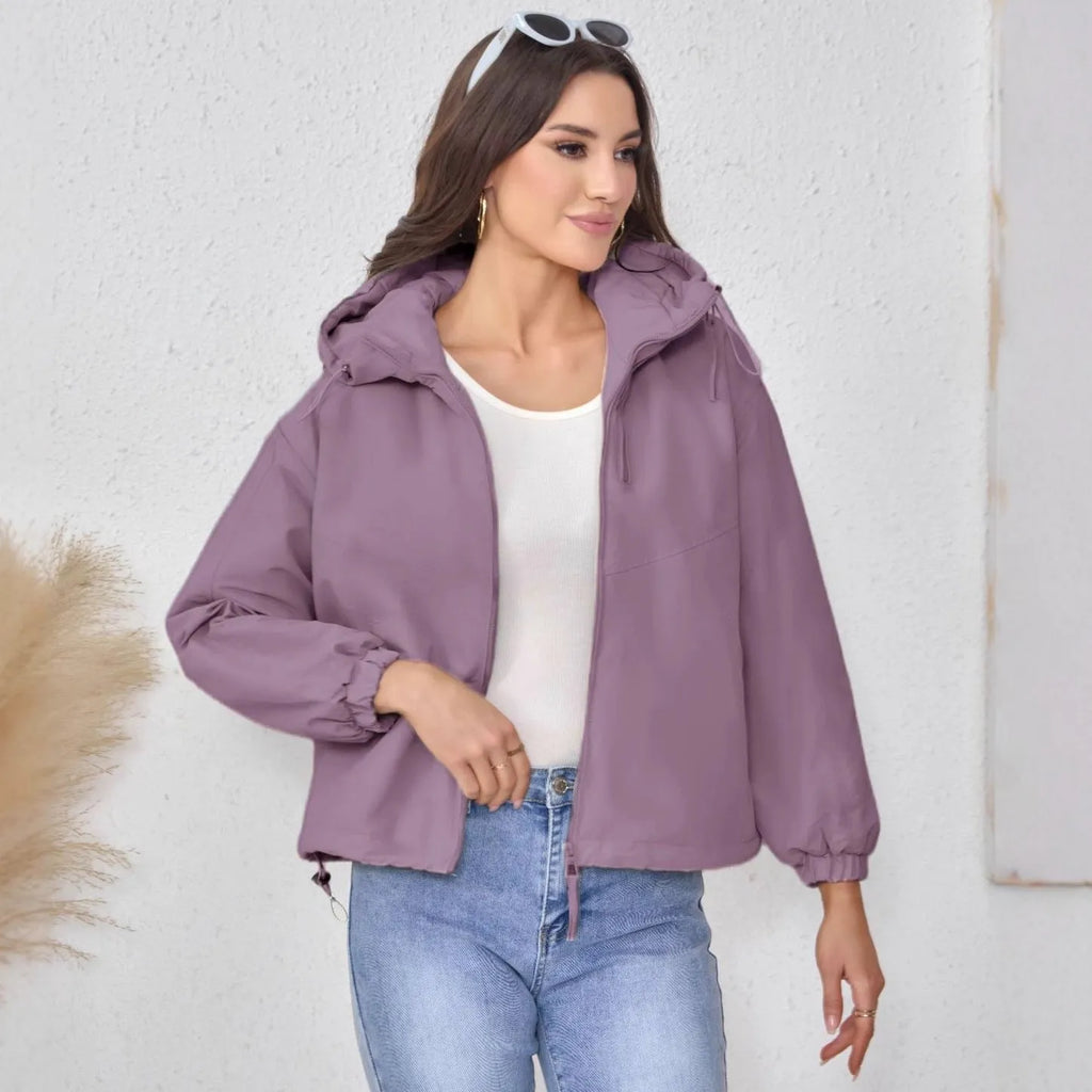 Women's loose-fit hooded shell jacket in grey, black, or purple colours, made from polyester fabric.