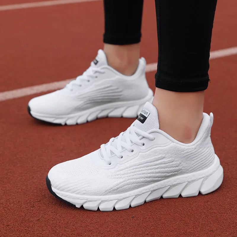Women's low-top black and white running sneakers with cross-strap detail and MD sole.
