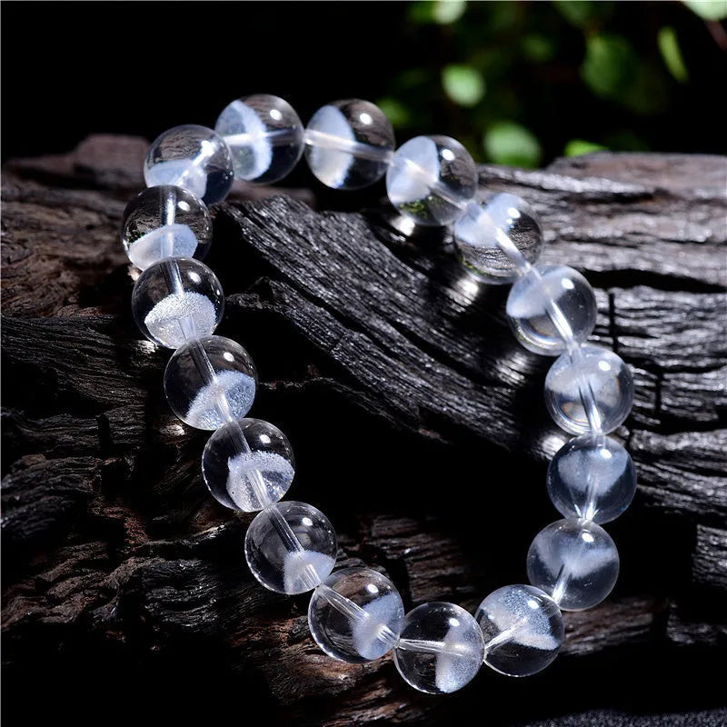 Women's white crystal pyramid bead bracelet with Ruyi design motif on a wrist.
