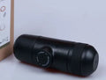 Black portable manual coffee machine showing compact 6x17.5cm design with stainless steel components
