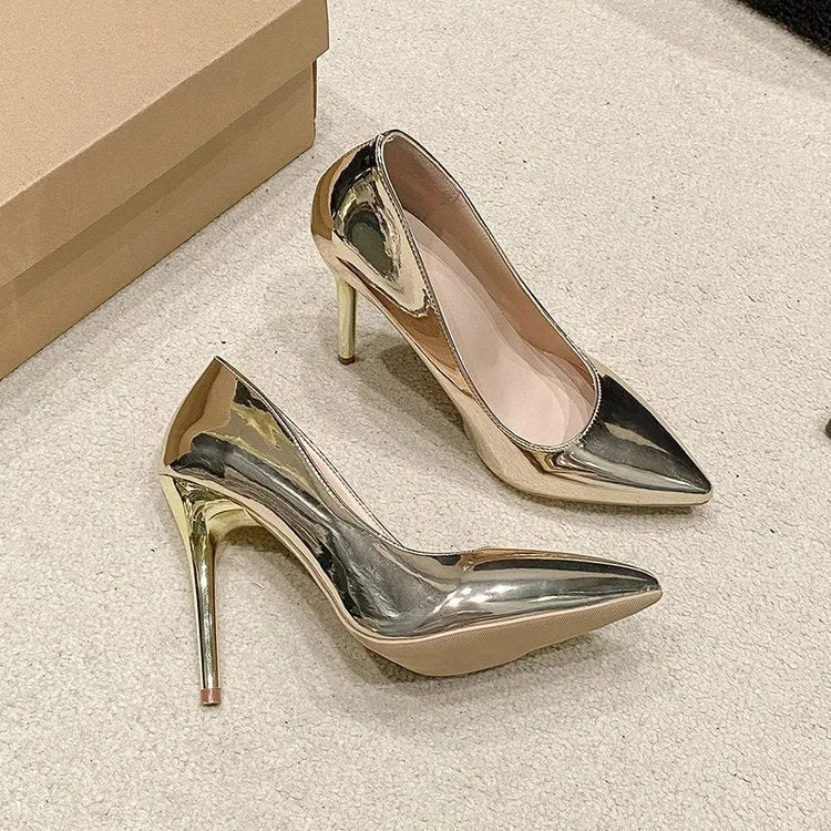 Gold pointed toe slip-on stiletto heel shoe on a white background.