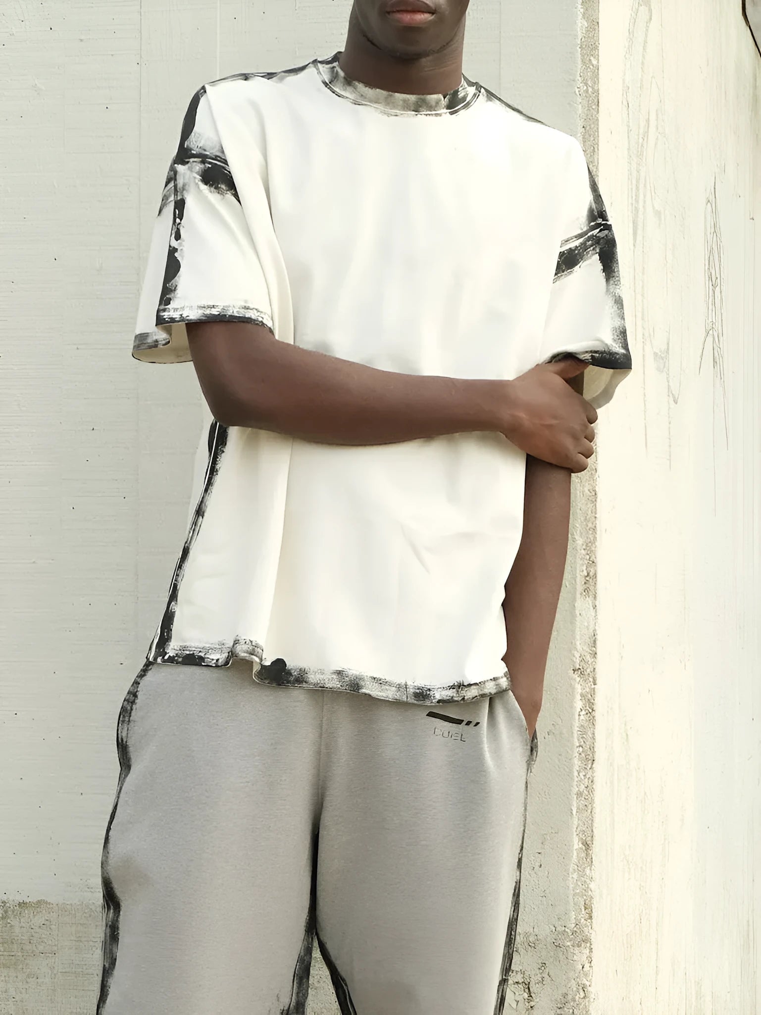 White casual short sleeve top with draped neckline and printed pattern on a hanger.