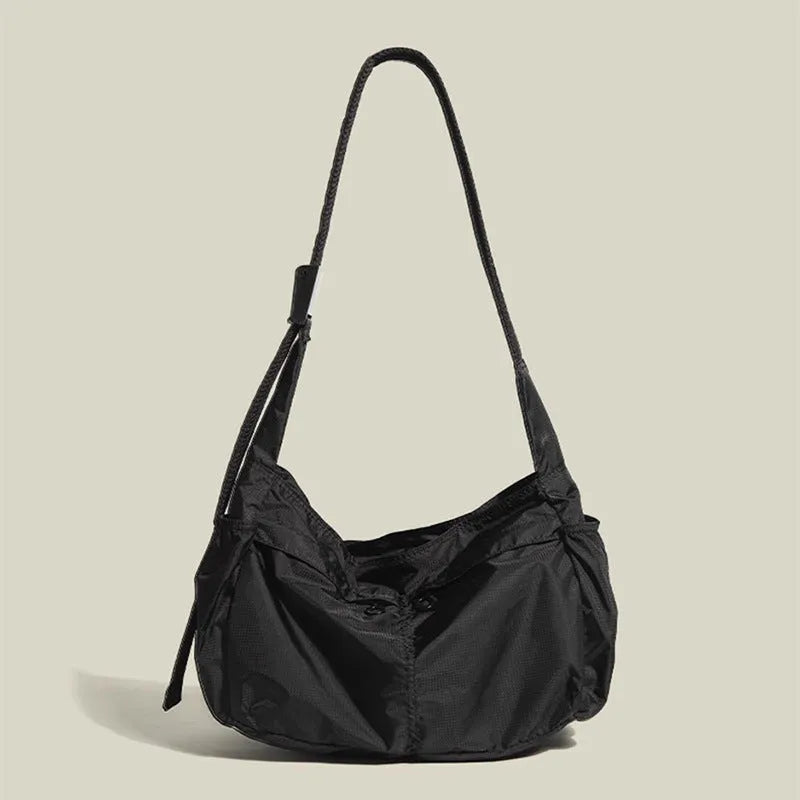 Casual black waterproof nylon messenger bag with single shoulder strap showing interior phone compartment