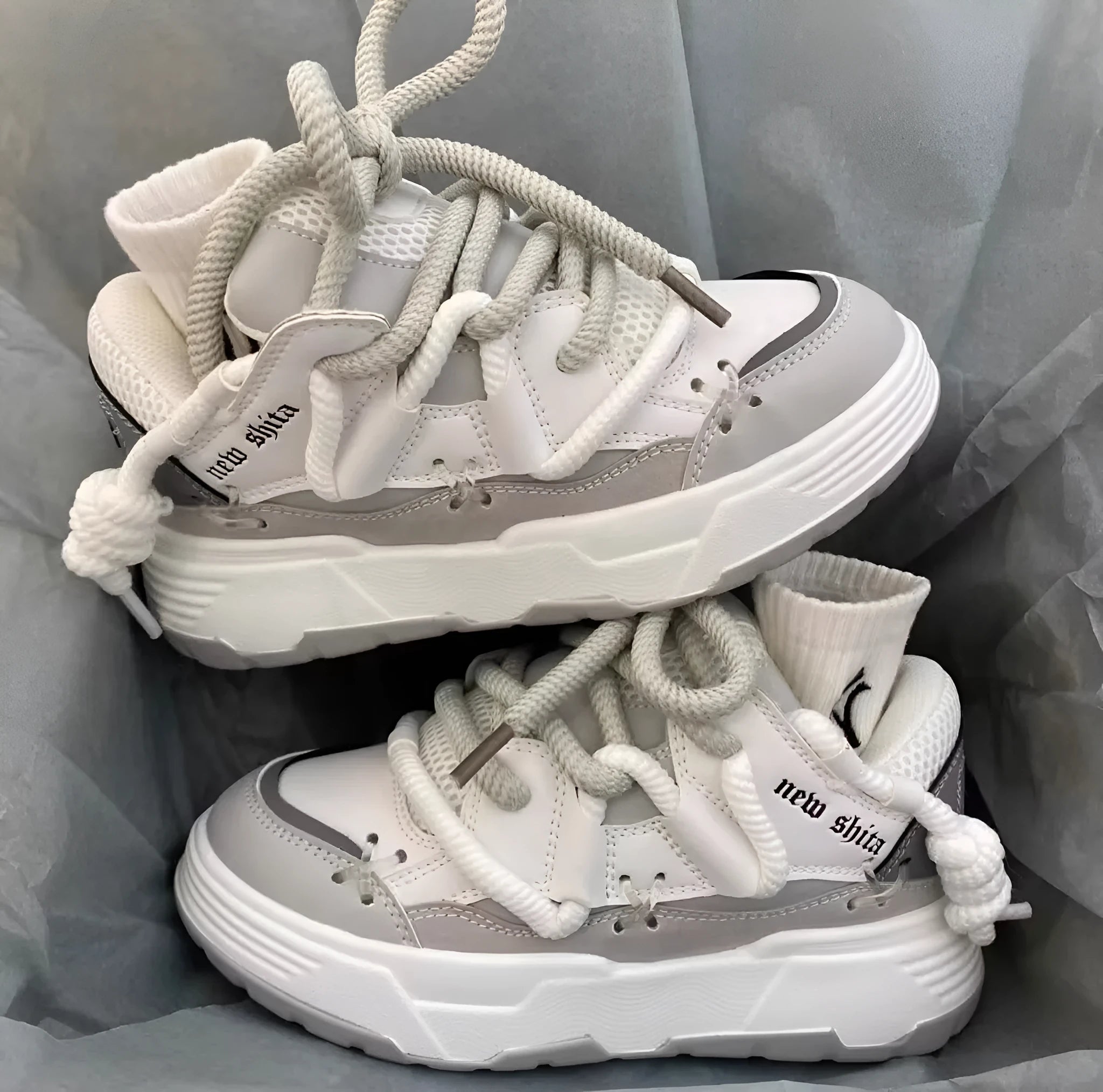 Grey retro clunky sneakers for women with thick sole for height increase and front lace-up closure.