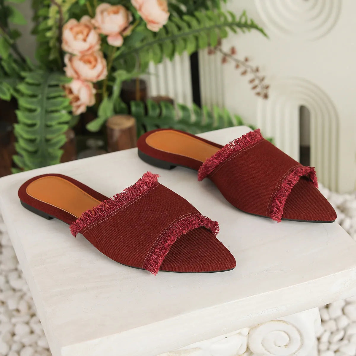 Women's denim slippers with leather lining, tassel detail, and a lightweight PVC sole.