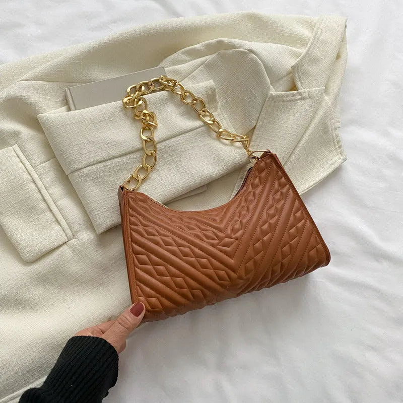 A women's black pleated chain baguette shoulder bag with a vertical square shape and an adjustable strap.