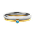 December birthstone engraved geometric ring in titanium steel with gold accents, shown on a finger.