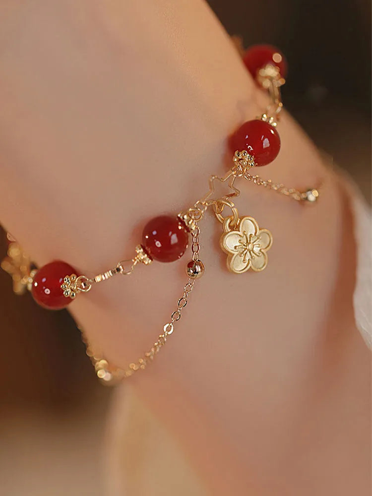 Close-up of a red agate double layer women's bracelet with floral and peach blossom motifs.