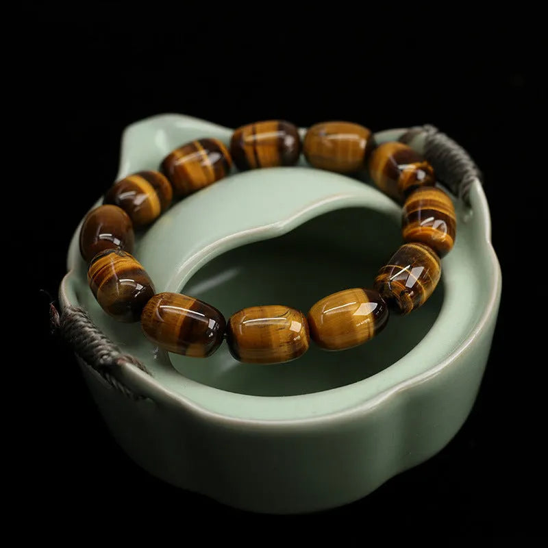 Yellow Tiger's Eye gemstone beaded bracelet with ethnic styling on a wrist.