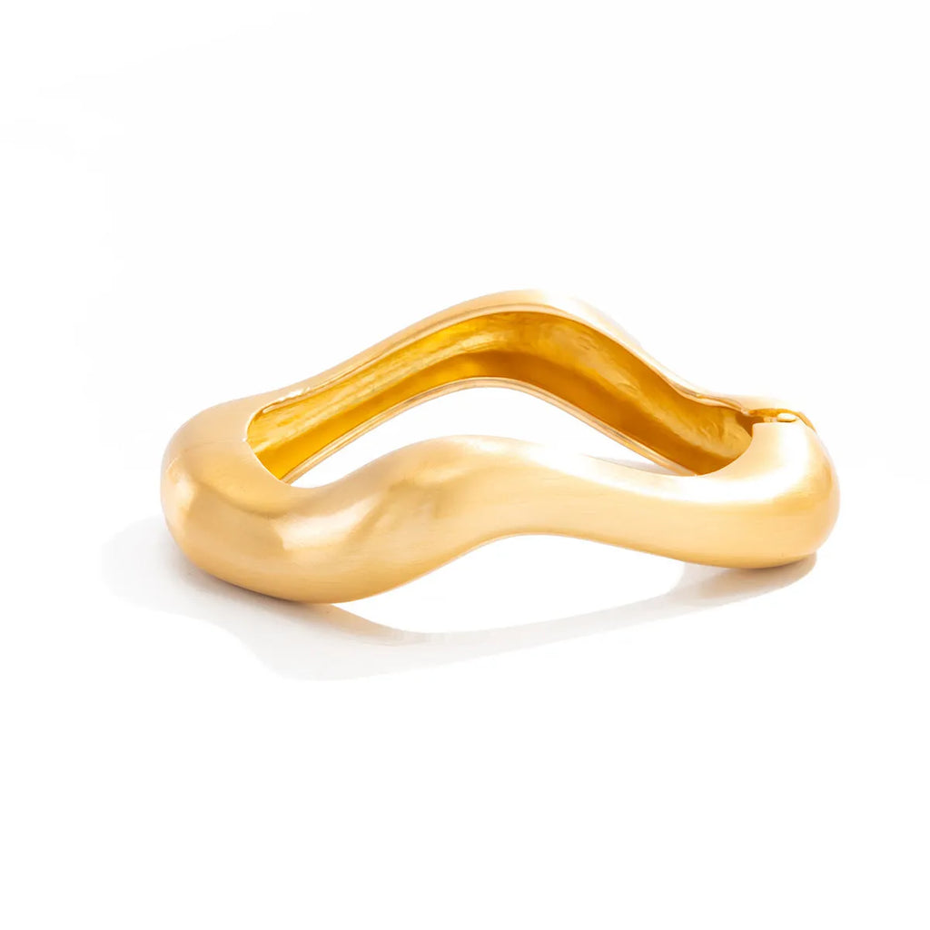 Electroplated alloy opening bracelet with elliptical motif in matte gold finish, cold wind style