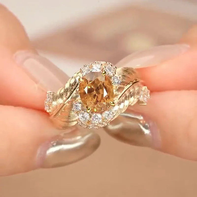 Gold-coloured embossed feather ring with geometric design and yellow zircon stone