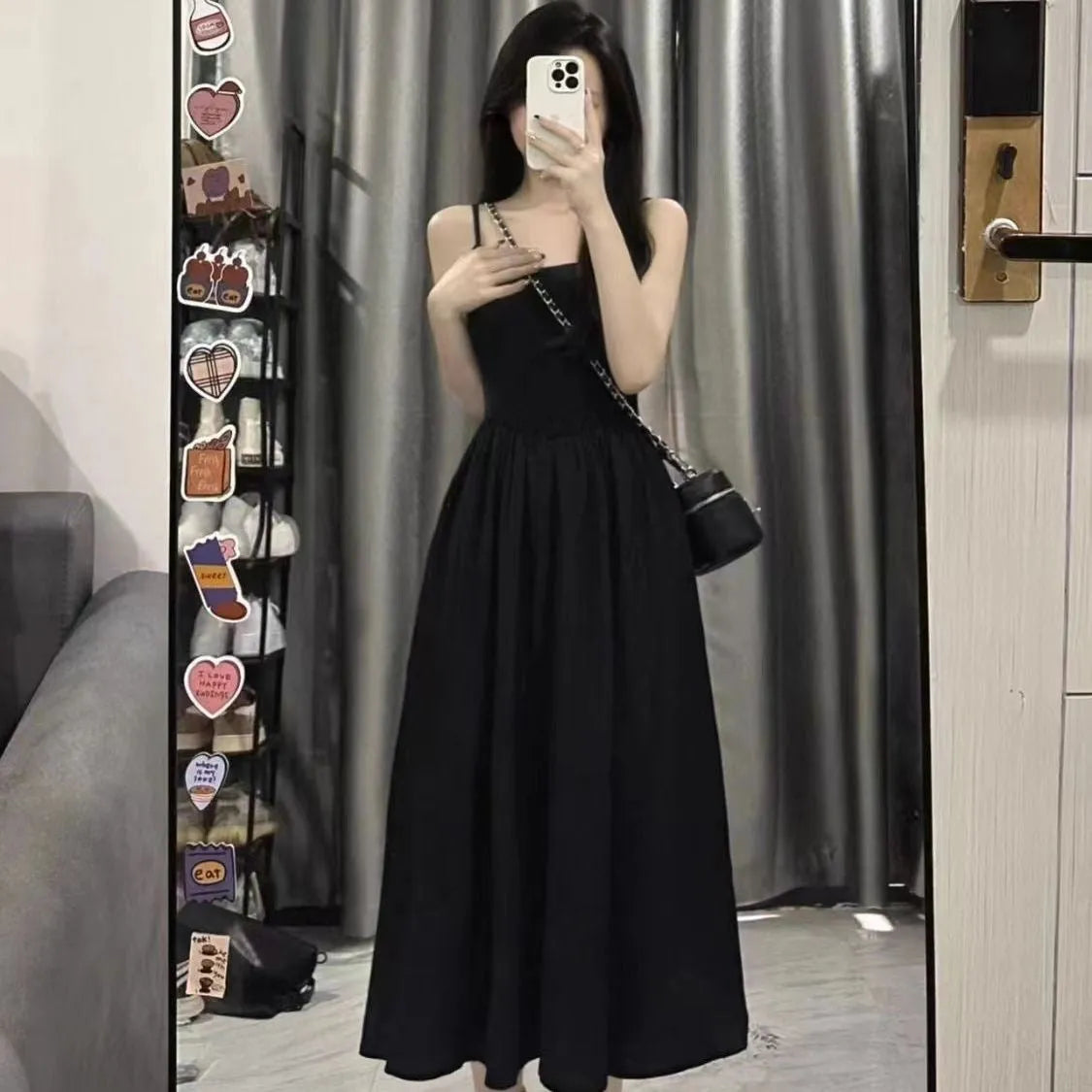 A-line slip dress in black with wide waist and sleeveless design made from polyester