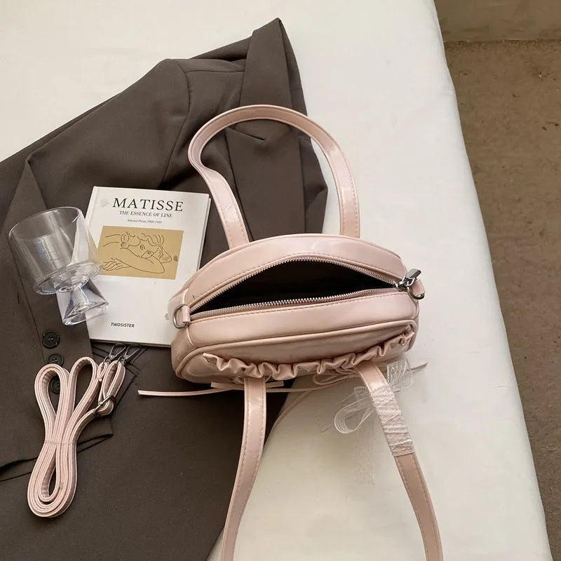 Women's PU leather handbag with bandage bow detail showing internal mobile phone pocket
