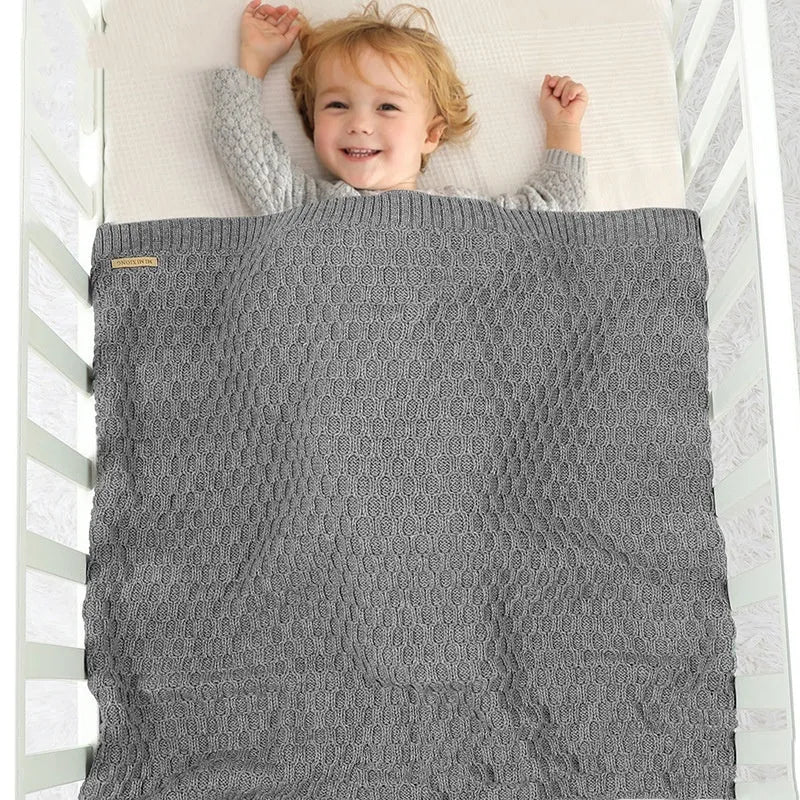 Acrylic infant hug blanket with textured lines pattern in a solid colour, shown flat at 70 by 90 cm.
