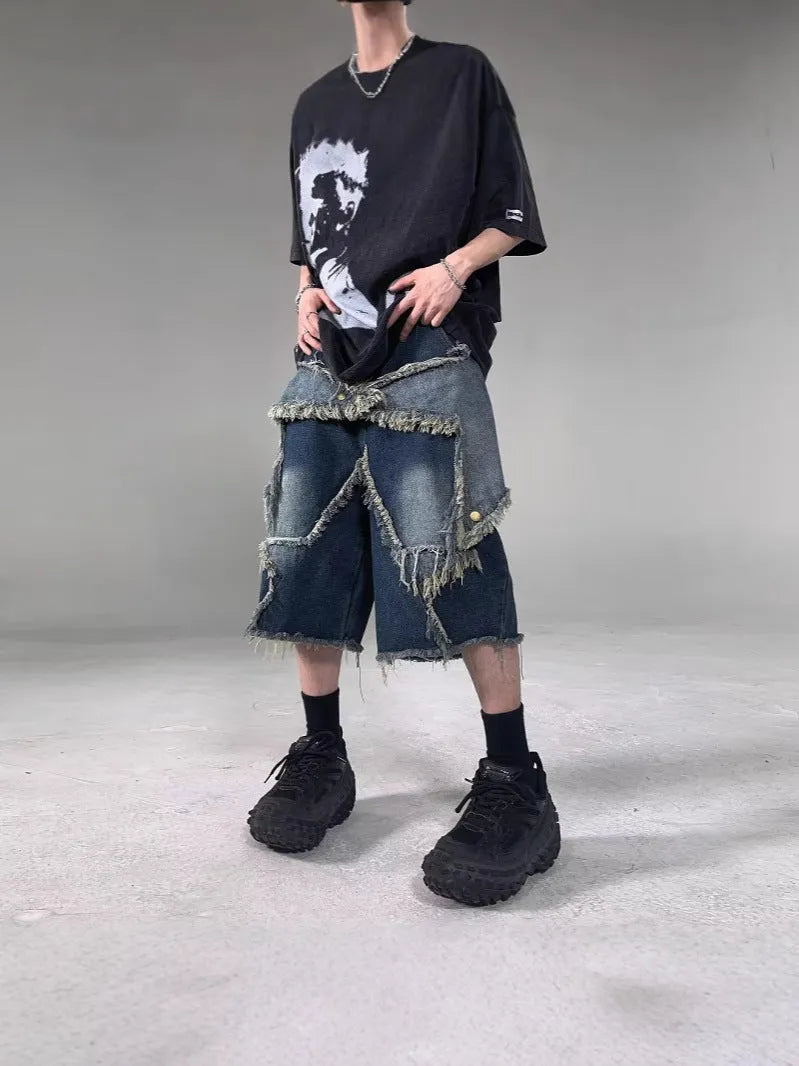 Blue denim shorts with a frayed hem and a large five-pointed star design on the leg, shown on a model.